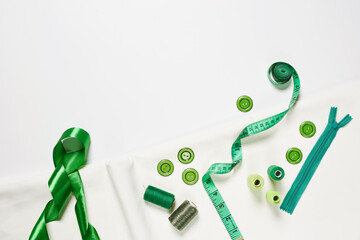 Sewing items from above. Flat lay composition with sewing accessories on light color background. Items for sewing, Sewing clothes, measuring tape, tailoring scissors, threads, buttons and needles