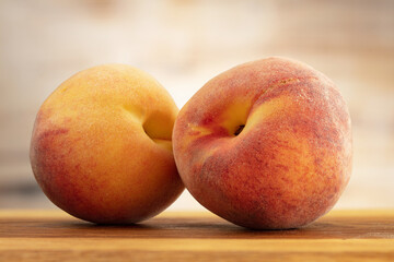 Two Peaches on a wooden board.