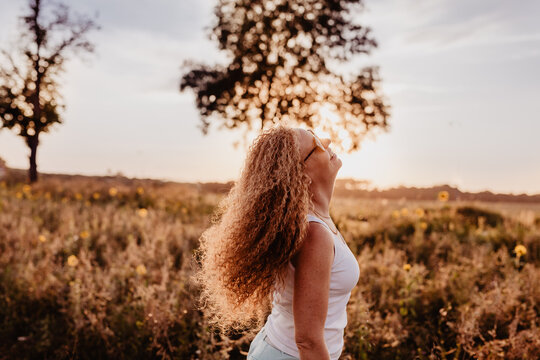 Powervolle und dynamische Frau im Sonnenuntergang, Abendhimmel