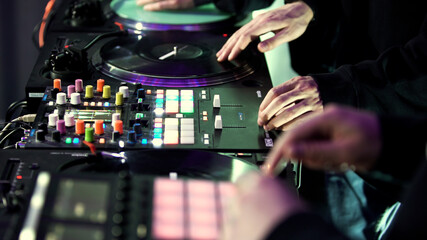 DJ group using console for mixing dance music at the disco club. Art. Deejays band and mixing deck, close up side view.