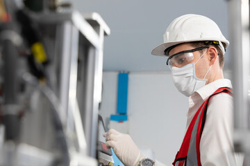 factory worker using touch screen industrial control panel machine for production