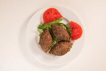 Traditional kebbe and pita bread on big round plate in lebanese restaurant. High quality photo