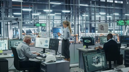 Car Factory Office: Team of Automotive Engineers Working, Using Computers to Design Advanced 3D Models for High-Tech Engines. Automated Robot Arm Industrial Assembly Line Manufacturing Vehicles