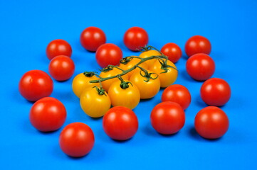 Yellow and red cherry tomatoes. Blue background