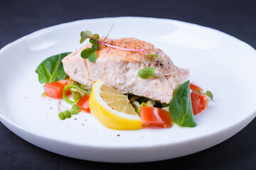 Trout (salmon) with vegetables, lemon and microgreens, cooked by the confit method. Traditional French dish. Step by step. Close-up.
