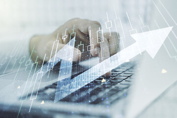 Double exposure of abstract creative financial diagram with upward arrow and hands typing on computer keyboard on background, growth and development concept