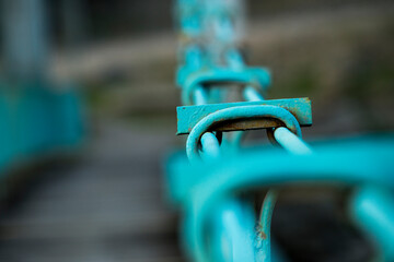 Detail image of the metal walkway of a pedestrian bridge painted a beautiful turquoise blue