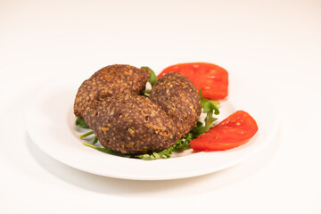Traditional kebbe and pita bread on big round plate in lebanese restaurant. High quality photo