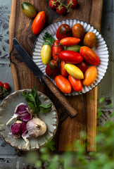 fresh cherry tomatoes and garlic on a wooden board
