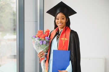 African American graduate holding diploma.