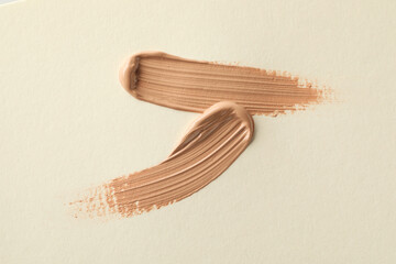 Sample of liquid skin foundation on beige background, top view