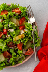 Light summer fresh salad with tomatoes and lettuce, chicken breast and pineapple with balsamic sauce, top view