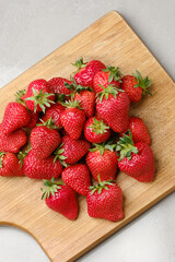 Pile of strawberries on a wooden kitchen board. 