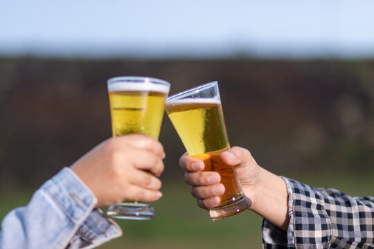 Two friends were happy toasting glasses and drinking beer on vacation.