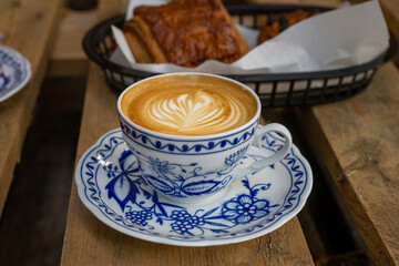cappuccino with milk foam leaf in a porcelain coffee cup, latte art