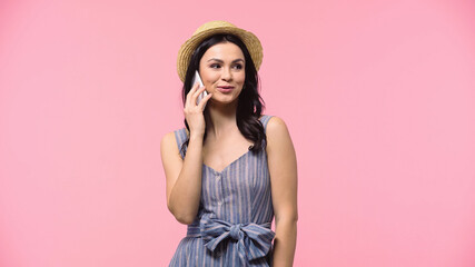 Young woman in sun hat talking on mobile phone isolated on pink.