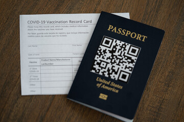COVID-19 Vaccination record card next to the QR code Passport of USA. Travel concept during pandemic