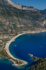 Amazing aerial view of Blue Lagoon in beach resort in the Fethiye district - Oludeniz.  Turkey. Summer landscape with mountains, green forest, turquoise coast in bright sunny day. Travel background.