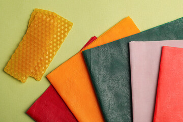 Different beeswax food wraps on light green background, flat lay