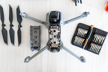 Top view disassembled drone on white background. Helix and tools around.