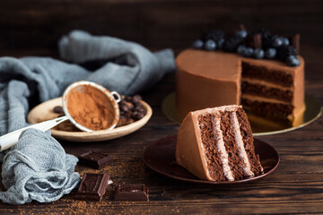 Festive chocolate cake. Cake for the party. Cocoa and chocolate pieces. A piece of cake on a plate. Birthday. Delicious dessert
