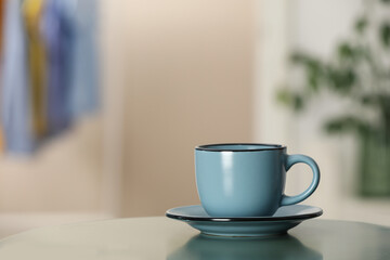 Ceramic cup on table in room, space for text