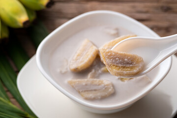 boiled banana in coconut milk,sliced banana in spoon.Thai dessert