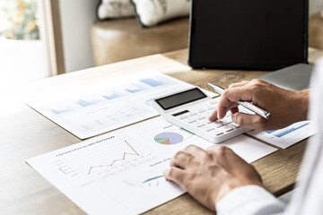 Financial scholars are pressing white calculators to calculate numbers on financial documents to verify the accuracy of company financial data line and pie chart documents. Finance concept.