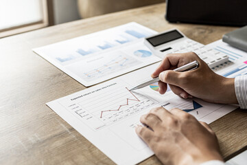 Financial scholars are looking at numbers on financial documents to verify the accuracy of company financial data, financial status documents line and pie charts. Finance concept.