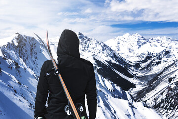 Extreme Ski Concept Person With Skis Overlooking Vast Snowy Mountain Wilderness - obrazy, fototapety, plakaty