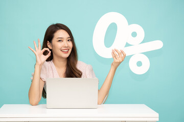Asian business woman sitting with laptop and showing 0% number or zero percent isolated over light...