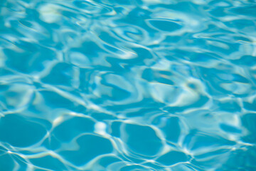 Hotel swimming pool with sunny reflections,sea wave close up, low angle view,blue water background.