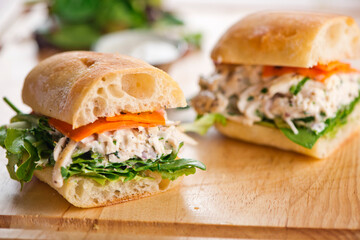 Chicken sandwiches. Served on toasted whole grain bread with melted Swiss cheese, mayonnaise and seasoned salt and pepper.  Classic American restaurant or diner lunch or brunch sandwich favorite.