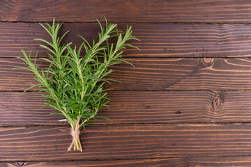 Fresh rosemary on a wooden background. Copy space.