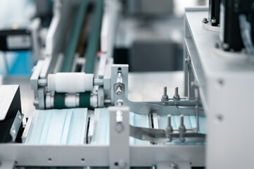 Scientists wearing protective clothing Inspect mask making machines in a laboratory at an industrial plant. Anti-virus production warehouse. concept of safety and prevention coronavirus covid-19.