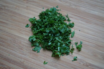 minced chopped smooth parsley on wooden board