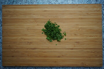 minced chopped smooth parsley on wooden board