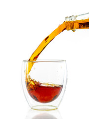 pouring whiskey into a transparent glass on a white background