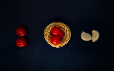 Spaghetti nest with cherry tomatoes and garlic. Food composition. Food photo
