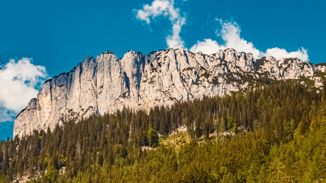 Beautiful alpine summer view with the famous Steinplatte summit and a cloud that looks like the Loch Ness Monster Nessi in the background near Waidring, Tyrol, Austria