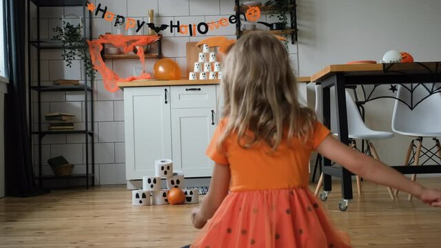 6-year old Little Girl Playing Pumpkin Bowling at Halloween Party. Slow Motion. Halloween Holiday Celebration Concept