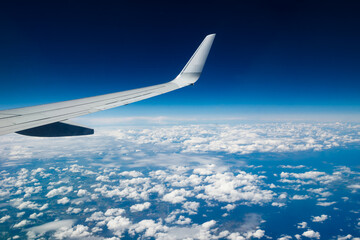 Fototapeta na wymiar Plain wing over blue sky. Flight from Helsinki to Amsterdam.