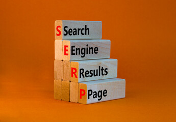 SERP symbol. Abbreviation SERP search engine results page on wooden blocks. Beautiful orange background. Copy space. Business and SERP search engine results page concept.