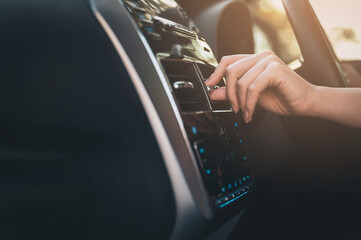 Closeup female hand adjusting air conditioning ventilation grill on car
