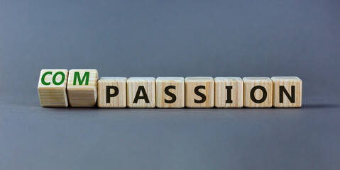 Passion or compassion symbol. Turned wooden cubes and changed the word compassion to passion. Beautiful grey table, grey background, copy space. Business, passion or compassion concept.