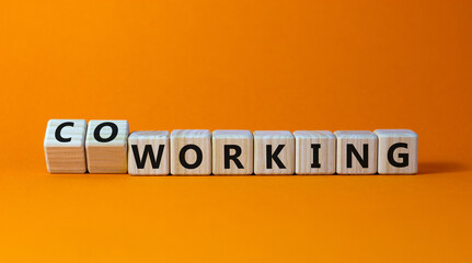 Working or coworking symbol. Turned a cube and changed the word 'working' to 'coworking'. Beautiful orange background. Business and working or coworking concept. Copy space.