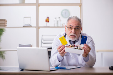 Old male doctor working in the clinic