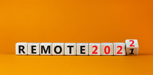 Planning 2022 remote new year symbol. Turned a wooden cube and changed words 'remote 2021' to 'remote 2022'. Beautiful orange background, copy space. Business, 2022 remote new year concept.