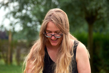 A closeup shot of a smiling white Caucasian girl in the park