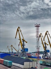 Freight trains and containers, cranes in the seaport.